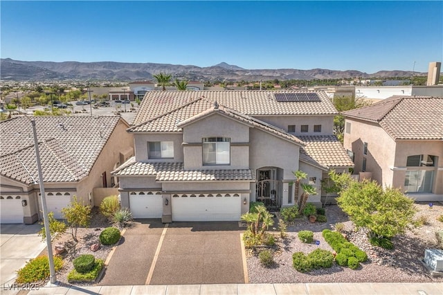 56 Ancient Hills Ln, Henderson, NV 89074 - mediterranean / spanish-style house with a tiled roof, stucco siding, a mountain view, an attached garage, and driveway