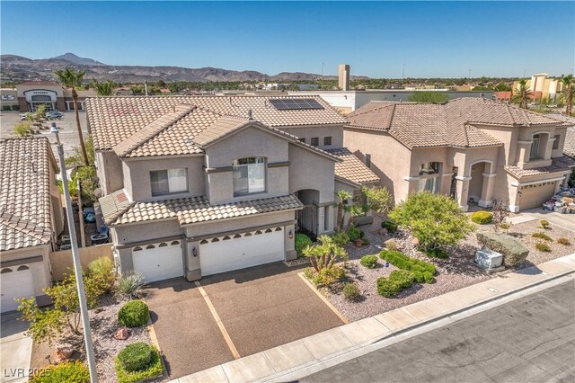 56 Ancient Hills Ln, Henderson, NV 89074 - mediterranean / spanish-style home with stucco siding, a tile roof, a garage, driveway, and a mountain view