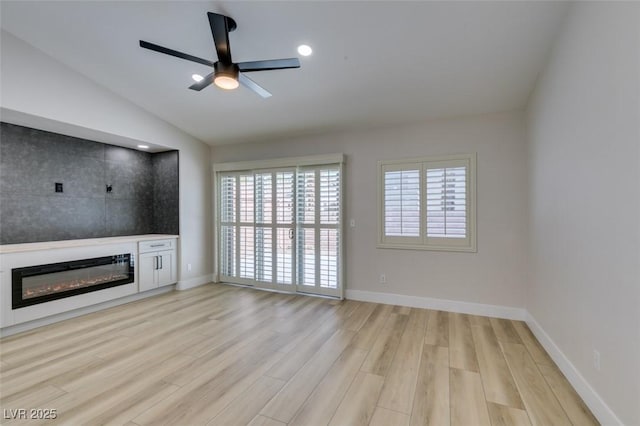 1844 Grand Prairie Ave, North Las Vegas, NV 89032 - unfurnished living room with light wood-style flooring, a glass covered fireplace, ceiling fan, vaulted ceiling, and recessed lighting
