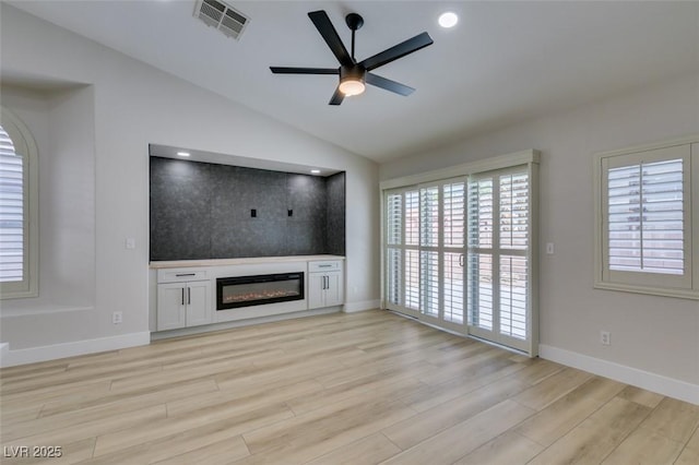 1844 Grand Prairie Ave, North Las Vegas, NV 89032 - unfurnished living room with light wood-style flooring, a glass covered fireplace, a ceiling fan, vaulted ceiling, and recessed lighting