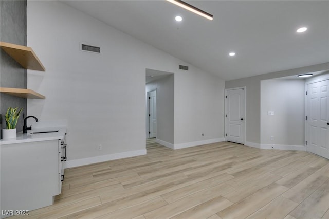 1844 Grand Prairie Ave, North Las Vegas, NV 89032 - unfurnished living room with lofted ceiling, light wood finished floors, and recessed lighting