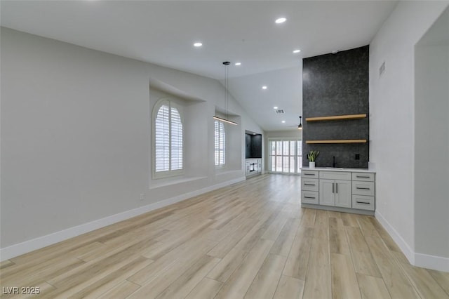 1844 Grand Prairie Ave, North Las Vegas, NV 89032 - unfurnished living room featuring light wood-type flooring, vaulted ceiling, and recessed lighting