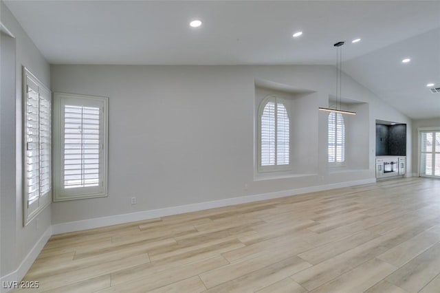 1844 Grand Prairie Ave, North Las Vegas, NV 89032 - unfurnished living room featuring vaulted ceiling, light wood-type flooring, and recessed lighting