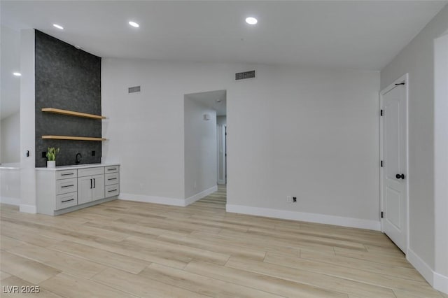 1844 Grand Prairie Ave, North Las Vegas, NV 89032 - unfurnished living room featuring vaulted ceiling, light wood-type flooring, and recessed lighting