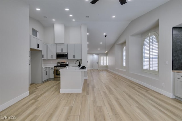 1844 Grand Prairie Ave, North Las Vegas, NV 89032 - kitchen featuring appliances with stainless steel finishes, light countertops, light wood finished floors, open floor plan, and recessed lighting