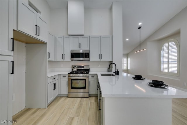 1844 Grand Prairie Ave, North Las Vegas, NV 89032 - kitchen featuring appliances with stainless steel finishes, a peninsula, light wood finished floors, light countertops, and recessed lighting