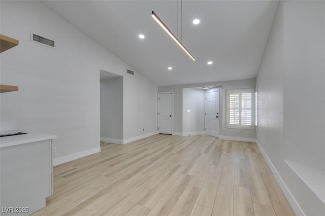 1844 Grand Prairie Ave, North Las Vegas, NV 89032 - unfurnished living room with lofted ceiling, light wood finished floors, and recessed lighting
