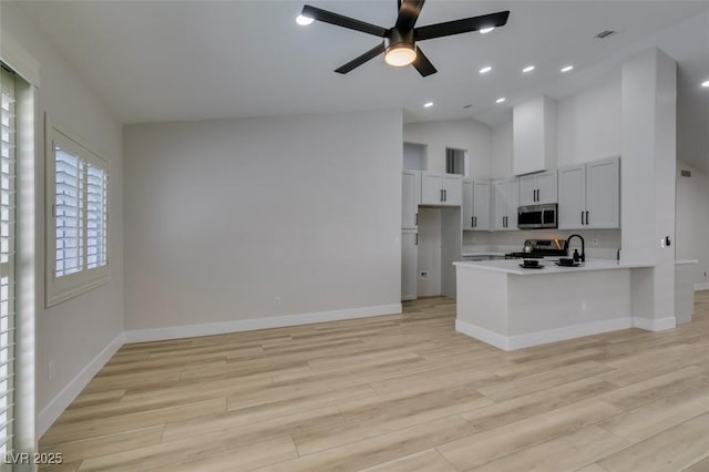 1844 Grand Prairie Ave, North Las Vegas, NV 89032 - kitchen featuring stainless steel appliances, a peninsula, light countertops, a ceiling fan, and light wood finished floors