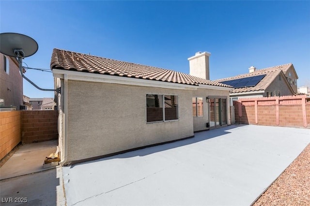 1844 Grand Prairie Ave, North Las Vegas, NV 89032 - back of house featuring a patio area, a tiled roof, a fenced backyard, and a chimney
