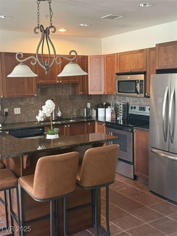 2455 W Serene Ave Unit 620, Las Vegas, NV 89123 - kitchen with stainless steel appliances, tasteful backsplash, a kitchen bar, and recessed lighting