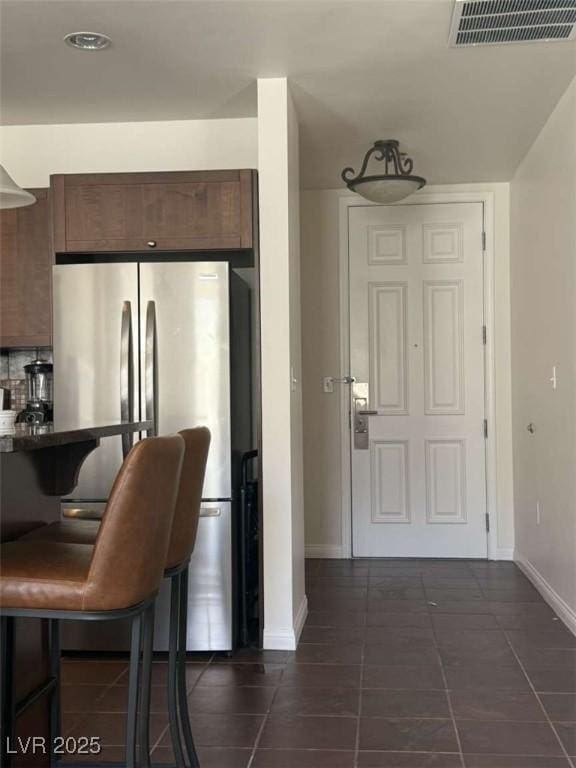 2455 W Serene Ave Unit 620, Las Vegas, NV 89123 - kitchen with freestanding refrigerator, dark tile patterned flooring, and a kitchen breakfast bar