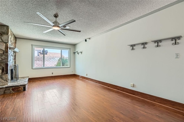 7704 Peacock Ave, Las Vegas, NV 89145 - unfurnished living room featuring a textured ceiling, a ceiling fan, a fireplace, and wood finished floors
