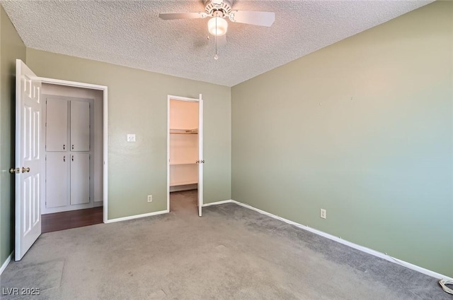7704 Peacock Ave, Las Vegas, NV 89145 - unfurnished bedroom with carpet, a textured ceiling, a walk in closet, and a ceiling fan