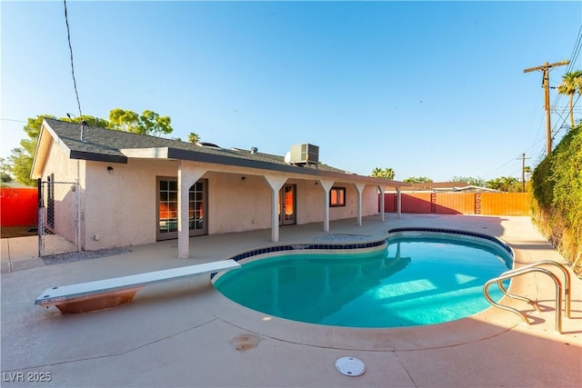 1571 Pawnee Dr, Las Vegas, NV 89169 - view of swimming pool featuring a diving board, a patio area, a fenced backyard, and a gate