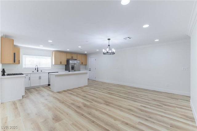 1571 Pawnee Dr, Las Vegas, NV 89169 - kitchen featuring stainless steel fridge with ice dispenser, a chandelier, crown molding, a kitchen island, and light countertops