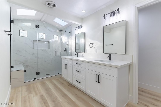 1571 Pawnee Dr, Las Vegas, NV 89169 - bathroom with a skylight, wood finished floors, double vanity, and a marble finish shower