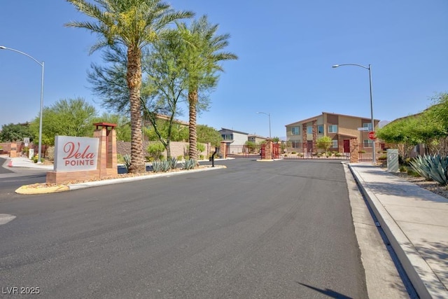 7212 Sunray Point St, North Las Vegas, NV 89084 - view of asphalt road with sidewalks, street lights, curbs, and traffic signs