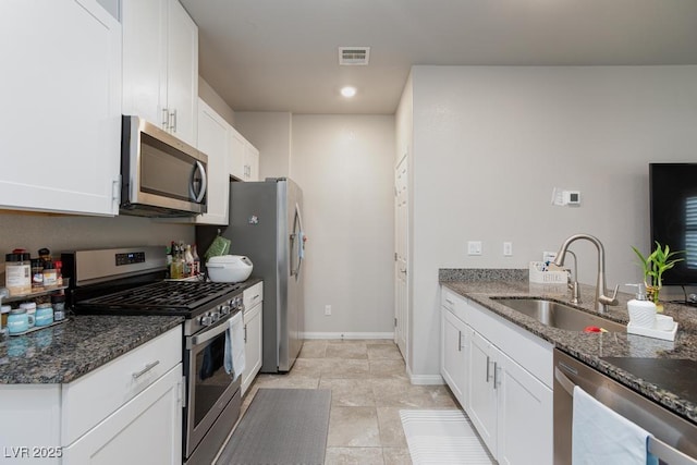 7212 Sunray Point St, North Las Vegas, NV 89084 - kitchen with stainless steel appliances, dark stone countertops, white cabinets, recessed lighting, and light tile patterned floors
