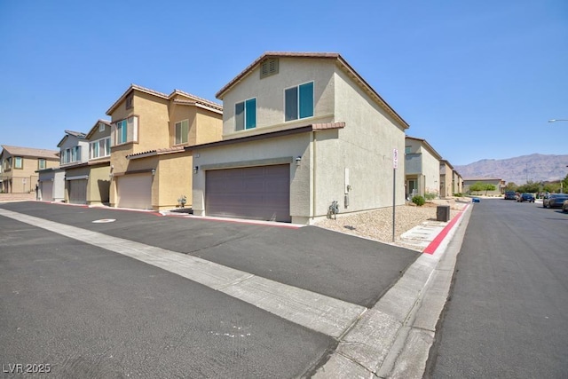 7212 Sunray Point St, North Las Vegas, NV 89084 - view of asphalt road featuring street lighting, a mountain view, a residential view, and curbs