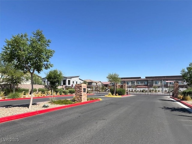 7226 N Decatur Blvd Unit 4, Las Vegas, NV 89131 - view of asphalt road featuring a gate, a gated entry, curbs, and a residential view