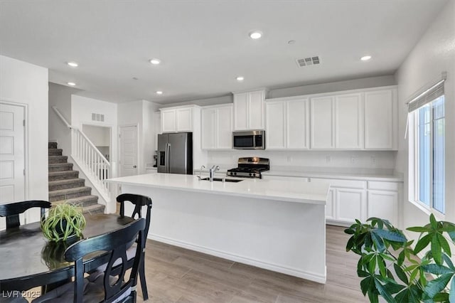 7226 N Decatur Blvd Unit 4, Las Vegas, NV 89131 - kitchen with stainless steel appliances, white cabinets, an island with sink, light countertops, and recessed lighting