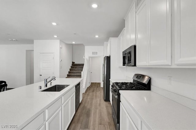 7226 N Decatur Blvd Unit 4, Las Vegas, NV 89131 - kitchen featuring stainless steel appliances, white cabinets, light countertops, light wood-style floors, and recessed lighting