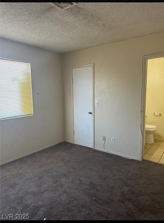 3420 Mercury St Unit B, North Las Vegas, NV 89030 - spare room featuring carpet flooring, a textured ceiling, and tile patterned flooring