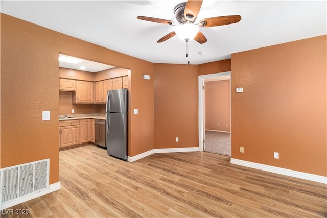 1948 Las Palmas Ln Unit 277, Laughlin, NV 89029 - kitchen with appliances with stainless steel finishes, a ceiling fan, light wood-type flooring, light brown cabinets, and light countertops