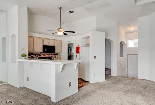 6201 E Lake Mead Blvd Unit 223, Las Vegas, NV 89156 - kitchen featuring light carpet, arched walkways, a peninsula, and freestanding refrigerator
