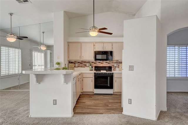 6201 E Lake Mead Blvd Unit 223, Las Vegas, NV 89156 - kitchen with a ceiling fan, light colored carpet, white appliances, a peninsula, and vaulted ceiling