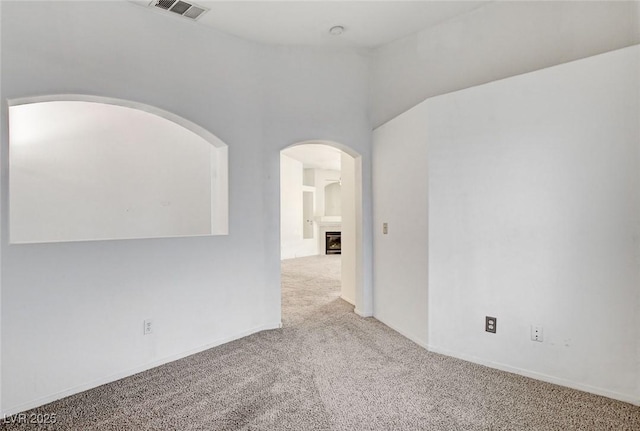 6201 E Lake Mead Blvd Unit 223, Las Vegas, NV 89156 - carpeted empty room featuring arched walkways and a fireplace