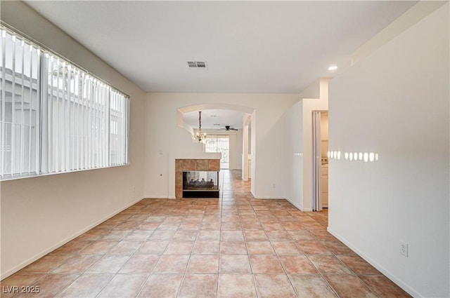 10612 Primrose Arbor Ave, Las Vegas, NV 89144 - unfurnished living room featuring arched walkways, a fireplace, and recessed lighting