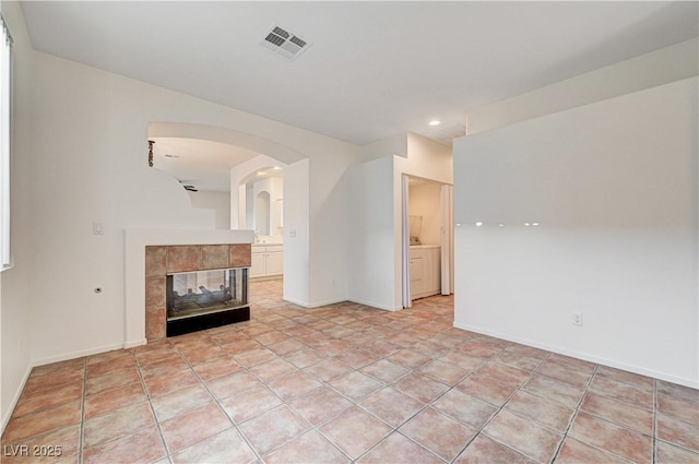 10612 Primrose Arbor Ave, Las Vegas, NV 89144 - unfurnished living room with arched walkways, a fireplace, and recessed lighting