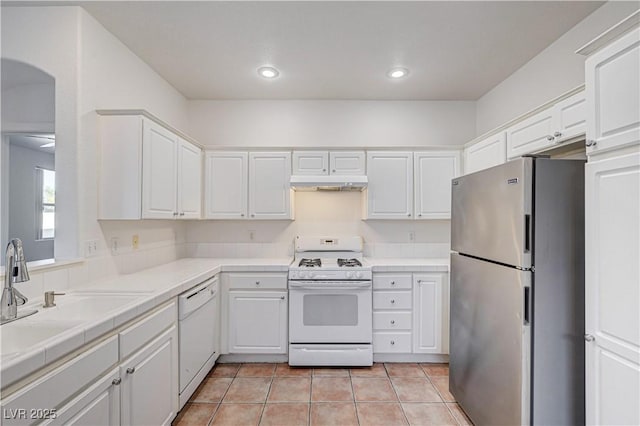 10612 Primrose Arbor Ave, Las Vegas, NV 89144 - kitchen featuring white appliances, under cabinet range hood, white cabinets, light tile patterned flooring, and tile counters