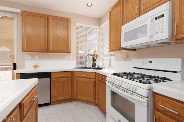 757 Roddenberry Ave, Las Vegas, NV 89123 - kitchen with white appliances, tile counters, recessed lighting, light marble finish floors, and brown cabinets