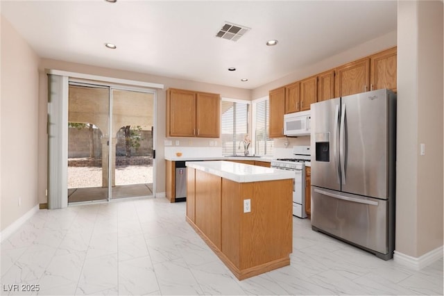 757 Roddenberry Ave, Las Vegas, NV 89123 - kitchen with white appliances, light marble finish flooring, light countertops, a center island, and recessed lighting