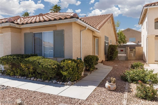757 Roddenberry Ave, Las Vegas, NV 89123 - view of side of property featuring a tiled roof, stucco siding, and a gate