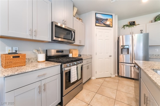 9237 Brayden Bay St, Las Vegas, NV 89178 - kitchen with stainless steel appliances, light tile patterned floors, and light stone counters