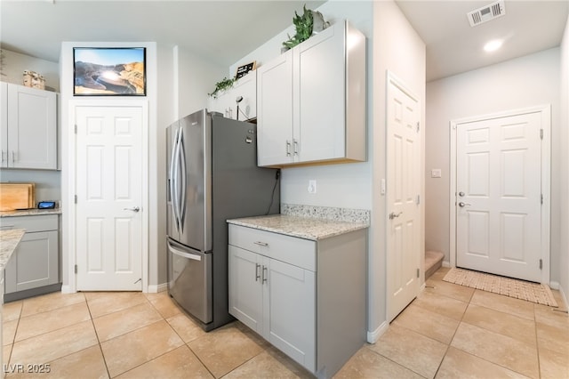 9237 Brayden Bay St, Las Vegas, NV 89178 - kitchen with freestanding refrigerator, light tile patterned floors, light stone counters, and recessed lighting