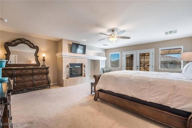 8929 Glenistar Gate Ave, Las Vegas, NV 89143 - bedroom with carpet, access to outside, a tiled fireplace, a ceiling fan, and french doors