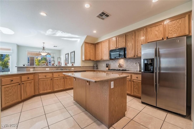 8929 Glenistar Gate Ave, Las Vegas, NV 89143 - kitchen featuring stainless steel appliances, light tile patterned floors, decorative backsplash, a kitchen island, and a peninsula