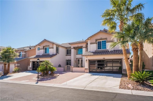 8929 Glenistar Gate Ave, Las Vegas, NV 89143 - mediterranean / spanish-style house featuring driveway, a garage, stucco siding, and a tiled roof