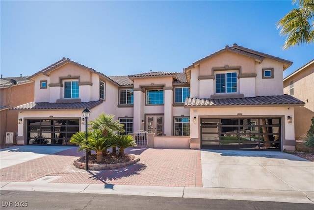 8929 Glenistar Gate Ave, Las Vegas, NV 89143 - mediterranean / spanish-style house featuring an attached garage, decorative driveway, and a tile roof