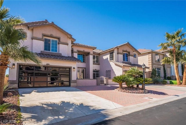 8929 Glenistar Gate Ave, Las Vegas, NV 89143 - mediterranean / spanish-style house with concrete driveway, a tiled roof, a garage, stucco siding, and a gate