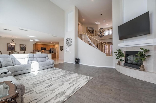 8929 Glenistar Gate Ave, Las Vegas, NV 89143 - living room featuring a high ceiling, a chandelier, stairway, a tiled fireplace, and recessed lighting