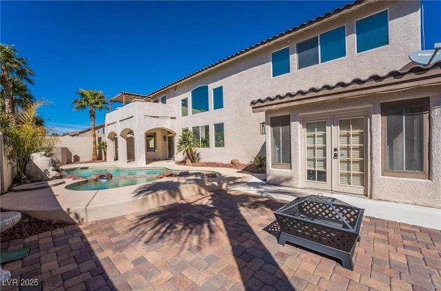 8929 Glenistar Gate Ave, Las Vegas, NV 89143 - view of swimming pool with french doors, a patio, an outdoor fire pit, and a pool with connected hot tub