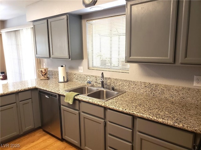 4816 Fiesta Lakes St, Las Vegas, NV 89130 - kitchen featuring stainless steel dishwasher, gray cabinets, light wood finished floors, light stone counters, and a peninsula