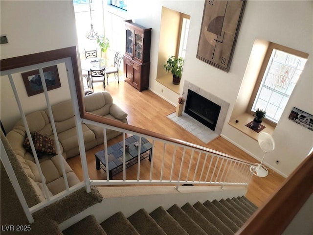 4816 Fiesta Lakes St, Las Vegas, NV 89130 - living room featuring wood finished floors, a tiled fireplace, and stairs