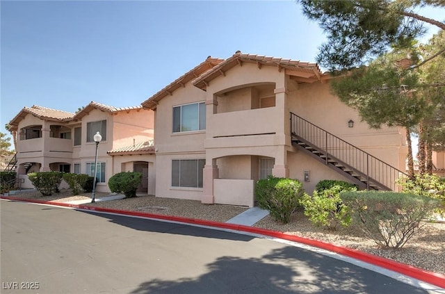 350 S Durango Dr Unit 202, Las Vegas, NV 89145 - view of front of home featuring a tile roof, stucco siding, and stairway