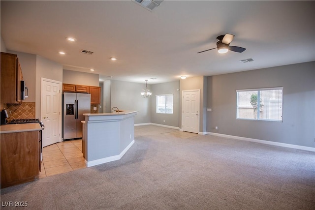 1155 Heavenly Harvest Pl Unit 3, Henderson, NV 89002 - kitchen featuring appliances with stainless steel finishes, brown cabinets, a chandelier, a ceiling fan, and light colored carpet